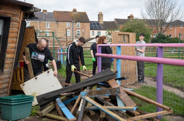 Jon and a group of young people helping tear down old enclosures at St James City Farm.